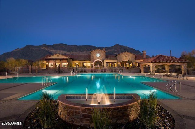 view of swimming pool with a mountain view, pool water feature, and a patio