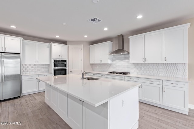 kitchen featuring white cabinets, sink, wall chimney exhaust hood, and stainless steel appliances