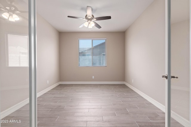 unfurnished room with ceiling fan, light wood-type flooring, and french doors