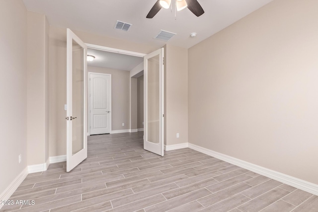 unfurnished room featuring ceiling fan, french doors, and light wood-type flooring