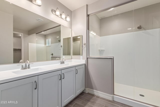 bathroom featuring a shower with door, vanity, and wood-type flooring