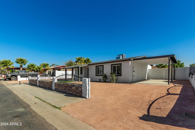 view of front of house featuring central AC and a carport