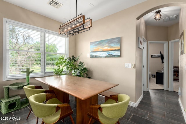 5612 S 21st Pl, Phoenix, AZ 85040 - dining space featuring arched walkways, a chandelier, and healthy amount of natural light