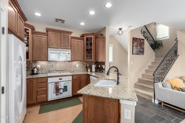 5612 S 21st Pl, Phoenix, AZ 85040 - kitchen with white appliances, a sink, a peninsula, open floor plan, and brown cabinets