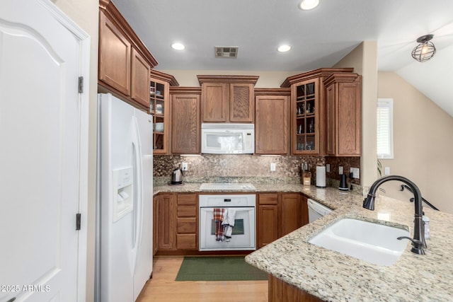 5612 S 21st Pl, Phoenix, AZ 85040 - kitchen featuring white appliances, a sink, brown cabinetry, light wood-style floors, and tasteful backsplash