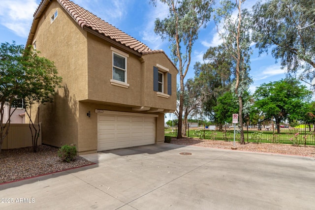 5612 S 21st Pl, Phoenix, AZ 85040 - view of side of property with an attached garage, stucco siding, and a tiled roof