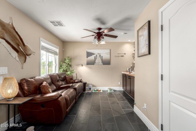 5612 S 21st Pl, Phoenix, AZ 85040 - living room featuring ceiling fan, dark tile patterned floors, and baseboards