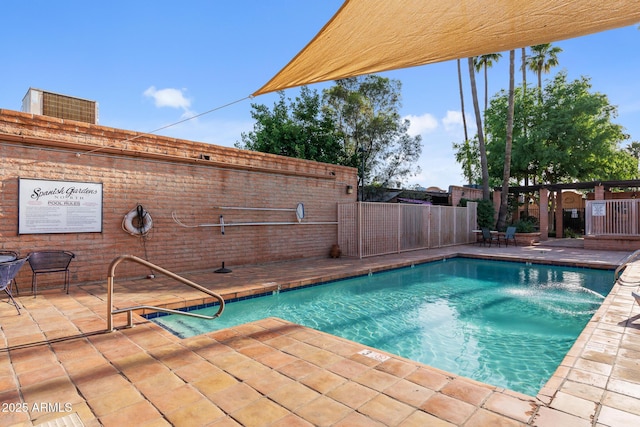 pool with a patio area and fence