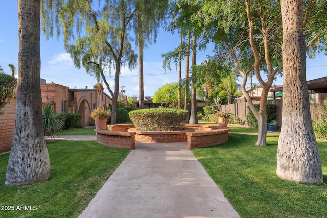 view of home's community with a yard and fence