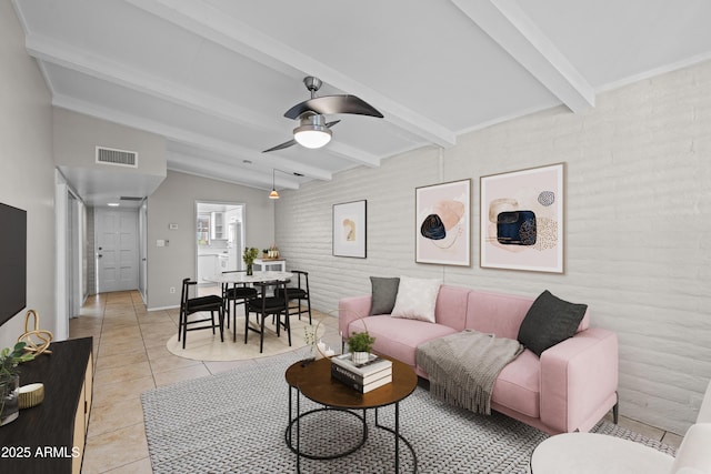 living area with visible vents, light tile patterned flooring, brick wall, baseboards, and ceiling fan