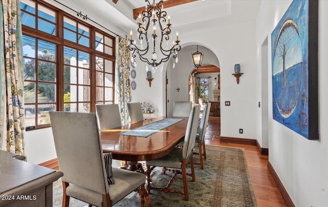 dining room featuring beamed ceiling, a notable chandelier, and dark hardwood / wood-style flooring