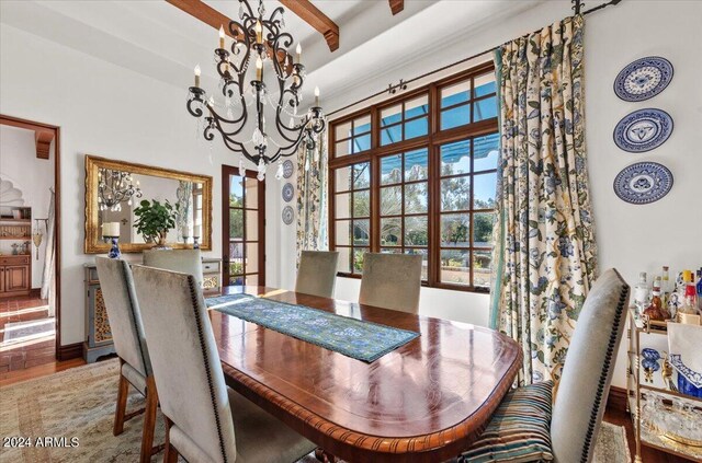 dining room featuring beam ceiling, a chandelier, and hardwood / wood-style flooring