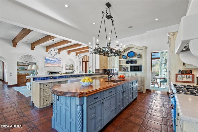 kitchen featuring butcher block countertops, hanging light fixtures, and a large island