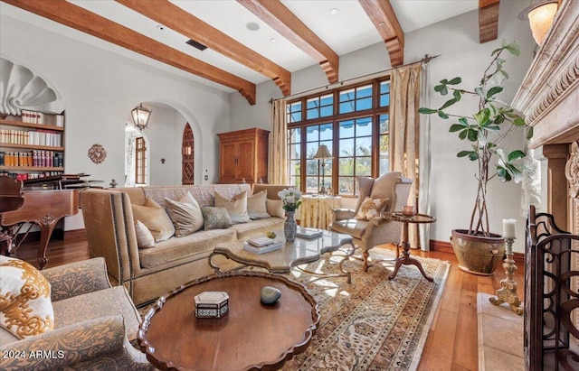 living room featuring beam ceiling and light wood-type flooring