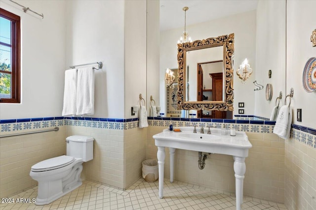 bathroom with tile patterned floors, toilet, and tile walls