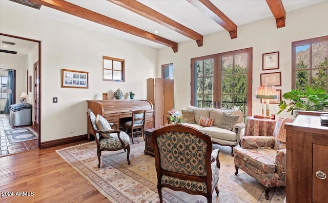 living room with beam ceiling, light hardwood / wood-style floors, and french doors