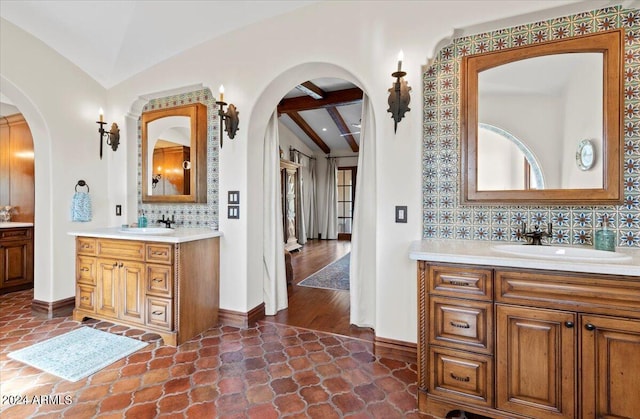 bathroom with vaulted ceiling with beams, decorative backsplash, and vanity