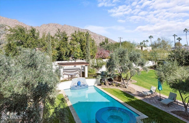 view of swimming pool featuring a lawn, a patio area, an in ground hot tub, and a mountain view