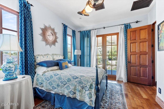 bedroom with access to outside, multiple windows, french doors, and light wood-type flooring