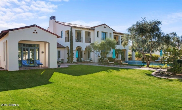 back of property featuring a yard and french doors