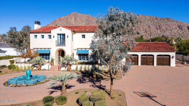 mediterranean / spanish-style home featuring a mountain view, a garage, and a balcony