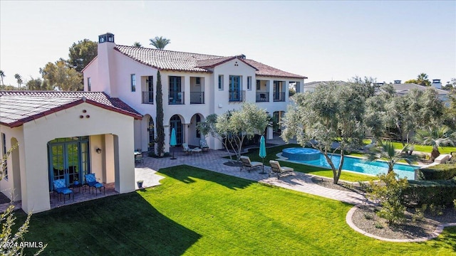 rear view of house featuring a lawn, a patio, and french doors