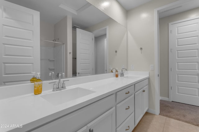 bathroom featuring tile patterned flooring, vanity, and walk in shower