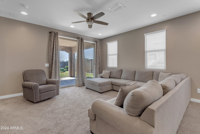 carpeted living room with ceiling fan