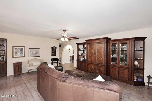 7537 W Bluefield Ave, Glendale, AZ 85308 - living room featuring arched walkways, brick floors, and a ceiling fan