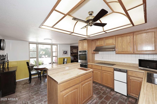 7537 W Bluefield Ave, Glendale, AZ 85308 - kitchen featuring under cabinet range hood, appliances with stainless steel finishes, brick flooring, a center island, and a ceiling fan