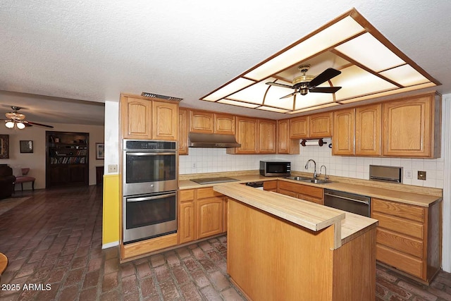 7537 W Bluefield Ave, Glendale, AZ 85308 - kitchen featuring appliances with stainless steel finishes, a ceiling fan, brick flooring, under cabinet range hood, and a textured ceiling