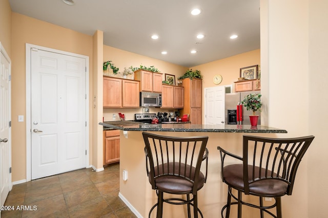 kitchen featuring a kitchen bar, kitchen peninsula, and appliances with stainless steel finishes