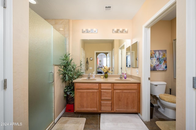 bathroom with tile patterned flooring, vanity, toilet, and walk in shower