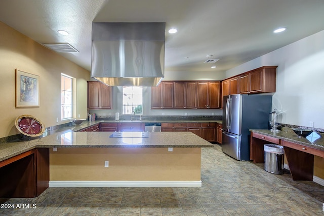 kitchen with kitchen peninsula, sink, dark stone counters, and appliances with stainless steel finishes