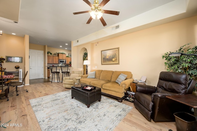 living room with ceiling fan and light hardwood / wood-style flooring