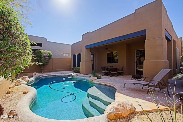 view of pool with a fenced in pool, a ceiling fan, an outdoor fire pit, a patio area, and fence