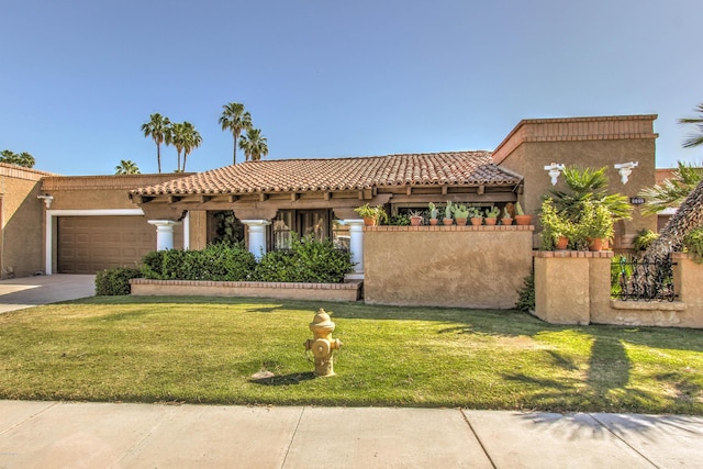 mediterranean / spanish house featuring a garage and a front lawn