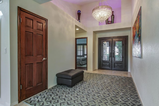 tiled foyer featuring an inviting chandelier and french doors