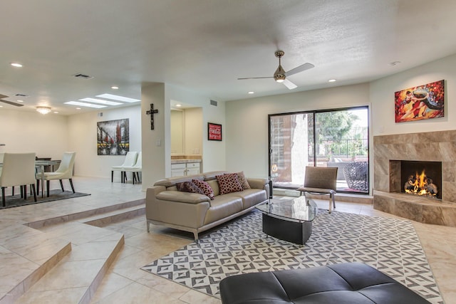 living room featuring ceiling fan and a fireplace