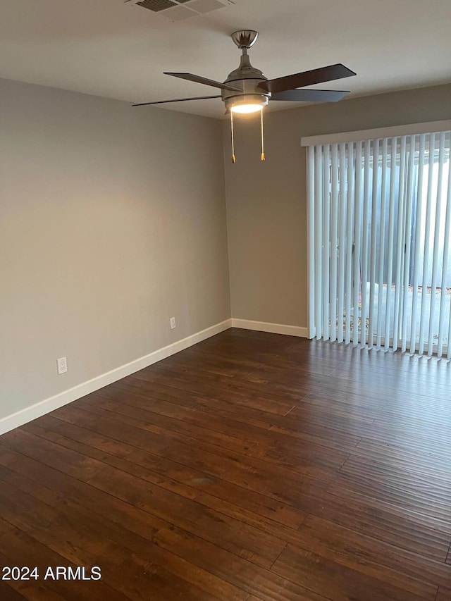 empty room with ceiling fan and dark wood-type flooring