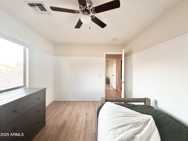bedroom featuring light wood finished floors, a ceiling fan, and visible vents