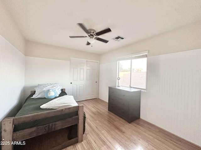 bedroom featuring a closet, visible vents, a ceiling fan, and light wood-type flooring