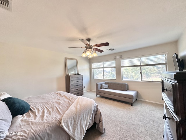 carpeted bedroom featuring a ceiling fan, visible vents, and baseboards