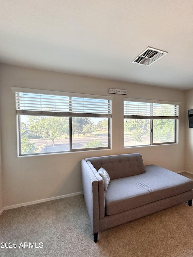 living area featuring visible vents, carpet flooring, and baseboards