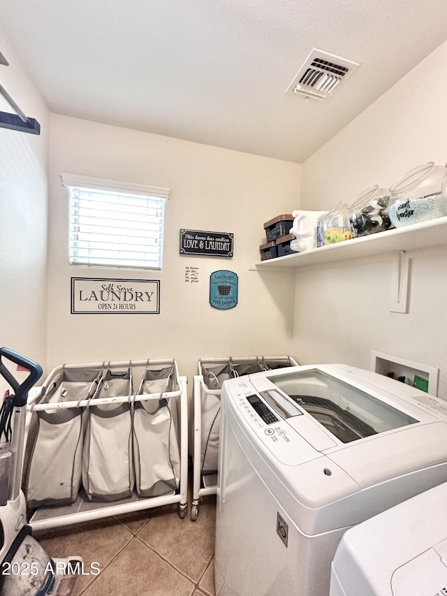 laundry area with visible vents, tile patterned flooring, laundry area, and washing machine and dryer