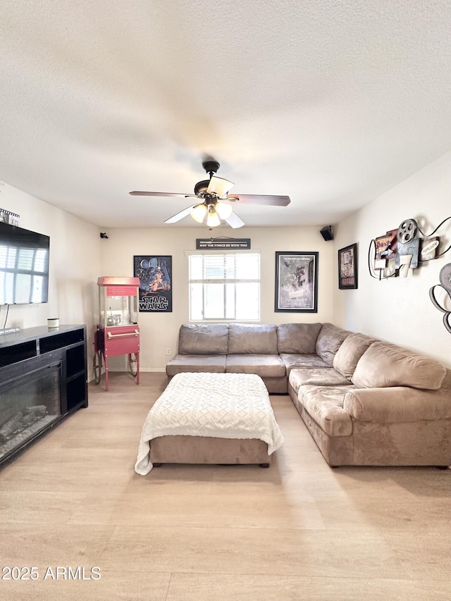 living room featuring a wealth of natural light, a ceiling fan, and a textured ceiling