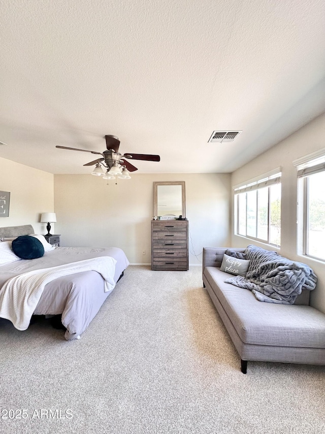 bedroom with visible vents, a ceiling fan, a textured ceiling, and carpet