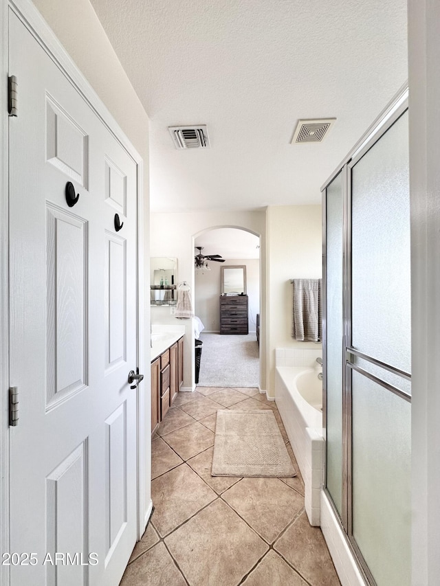 ensuite bathroom featuring tile patterned floors, visible vents, connected bathroom, and a garden tub