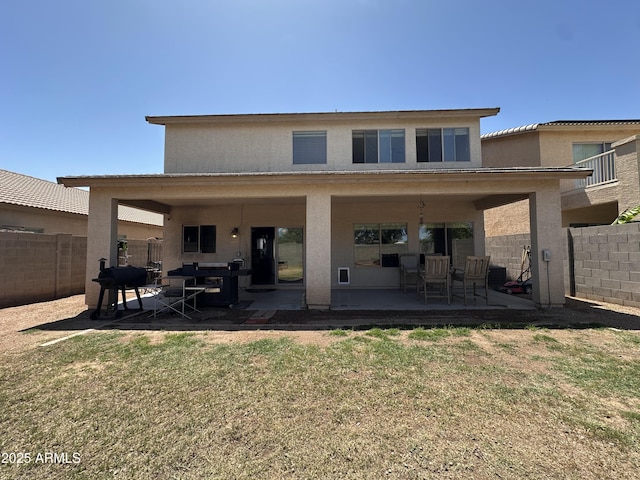 back of property featuring a patio, a yard, stucco siding, and a fenced backyard