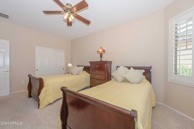 carpeted bedroom with a closet and ceiling fan